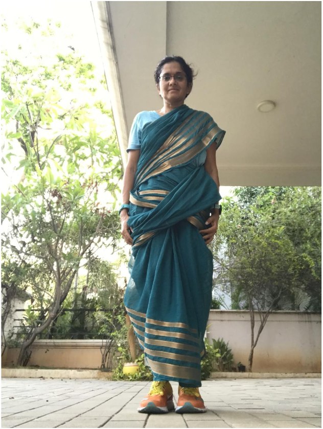 Jayanthi standing in her first 9-yard sari