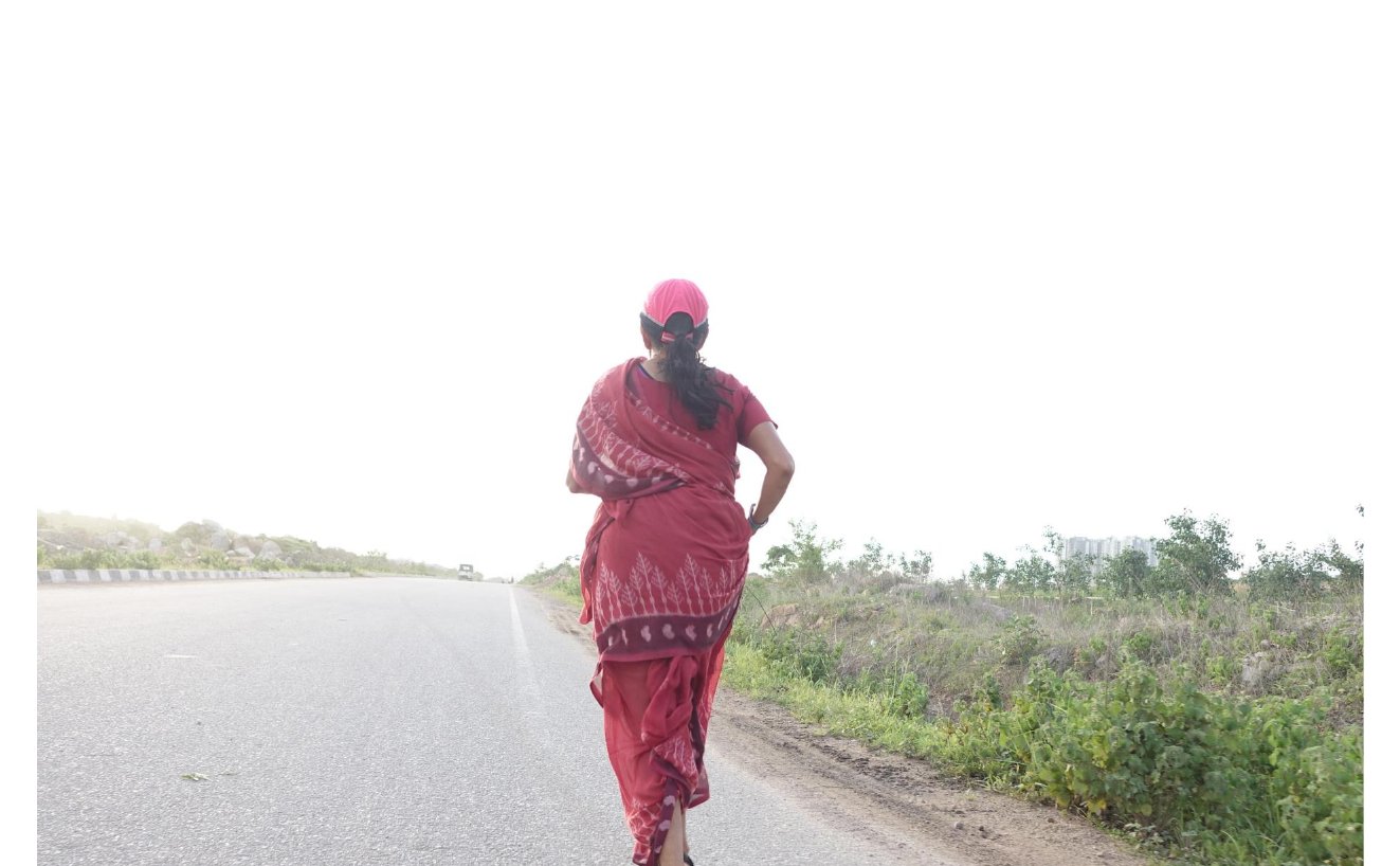 Jayanthi running on a road in a red sari